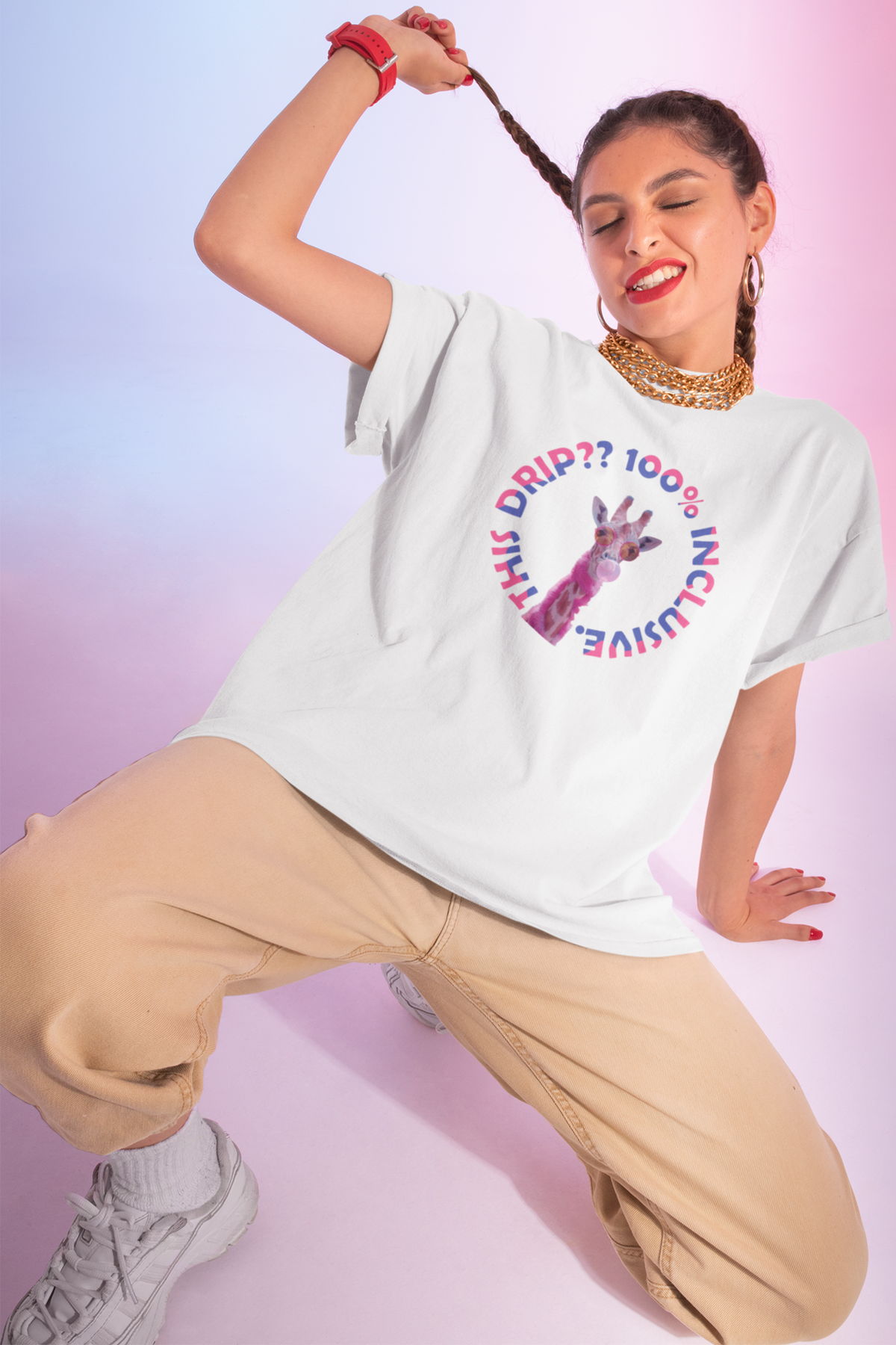 Inclusive fashion-forward white t-shirt from ANTI with a playful pink giraffe and bold “100% Inclusive Drip??” circular text in rainbow tones, worn by a gender-fluid model exuding confidence and joy against a dreamy, pastel ombré background.
