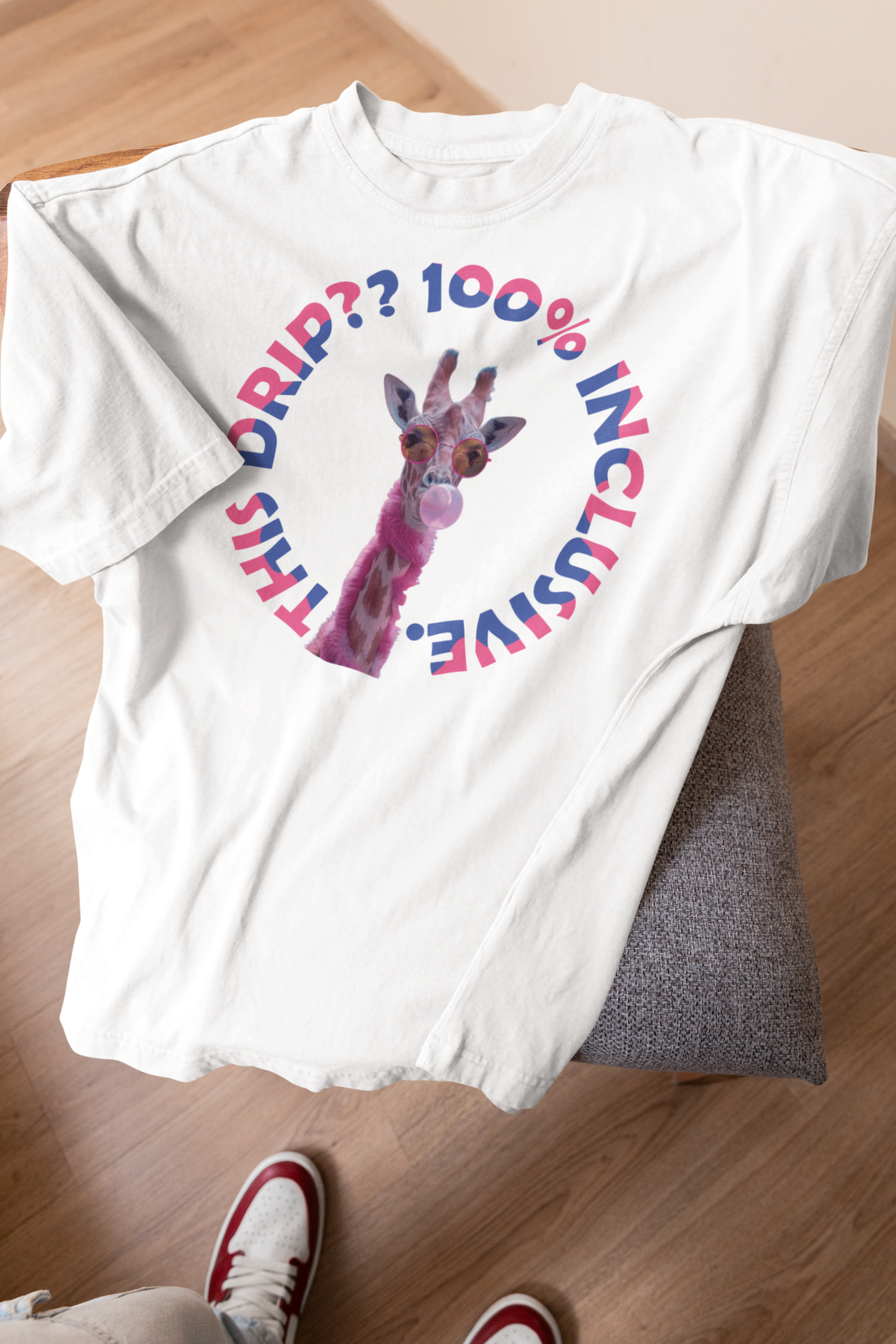White gender-inclusive t-shirt with a playful pink giraffe blowing bubble gum, wearing tinted sunglasses, surrounded by circular rainbow-colored text reading “THIS DRIP?? 100% INCLUSIVE.” A bold, statement piece from ANTI’s queer-positive collection, perfect for expressing pride and individuality.
