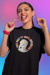 Person wearing a black unisex t-shirt with a bold graphic of a Greco-Roman statue in rainbow sunglasses, surrounded by the vibrant text "This Drip?? 100% Inclusive" — representing LGBTQIA+ pride and gender-fluid streetwear style.