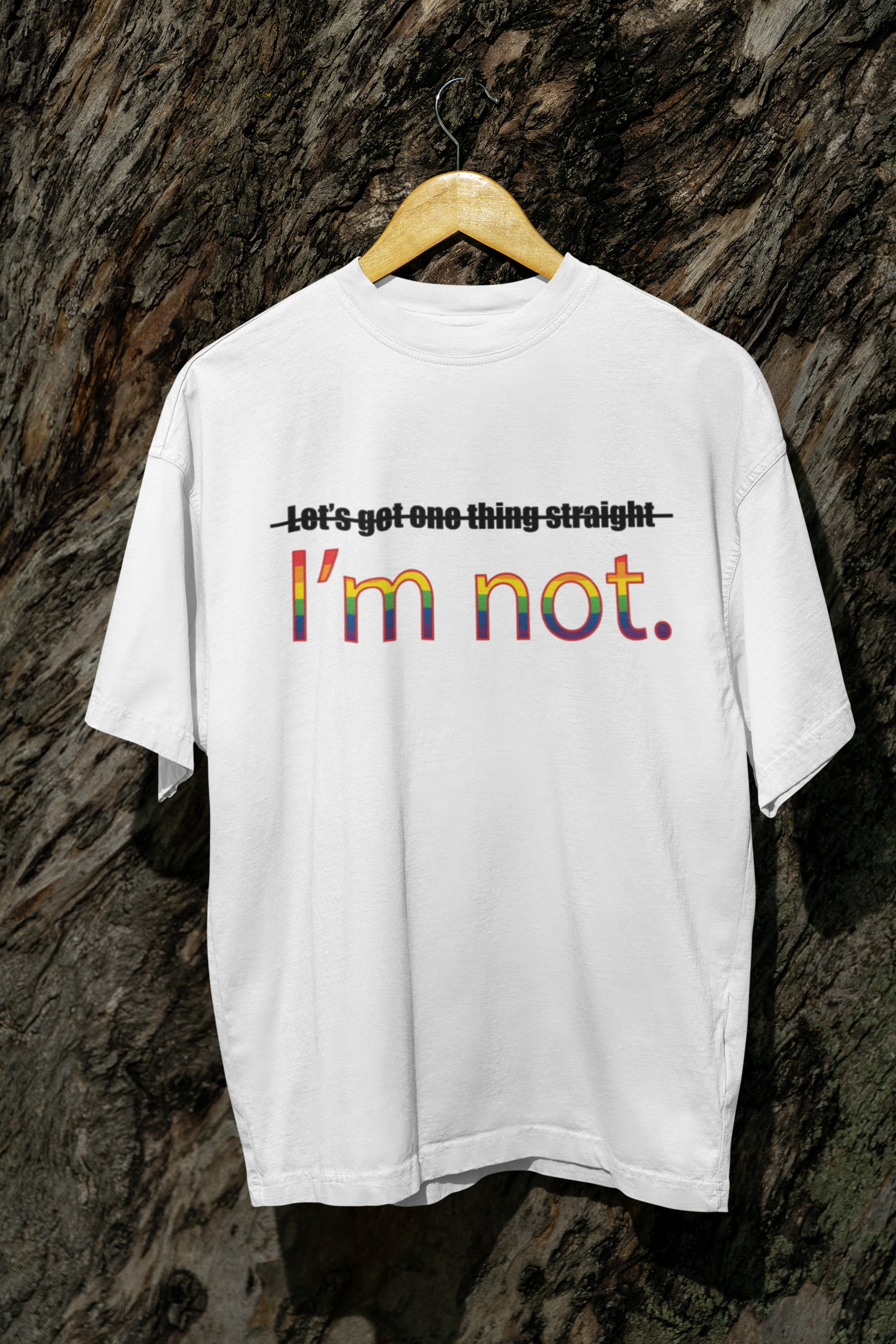 "White ‘I’m NOT’ oversized tee hanging up – ANTI’s gender-neutral streetwear with a bold LGBTQIA+ message."

