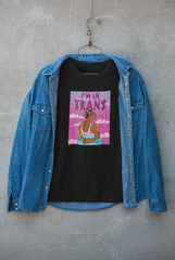 Edgy layered streetwear look featuring black "I’M IN TRANS" t-shirt under a dark jacket, styled by a queer model; bold, inclusive trans pride outfit by ANTI.

