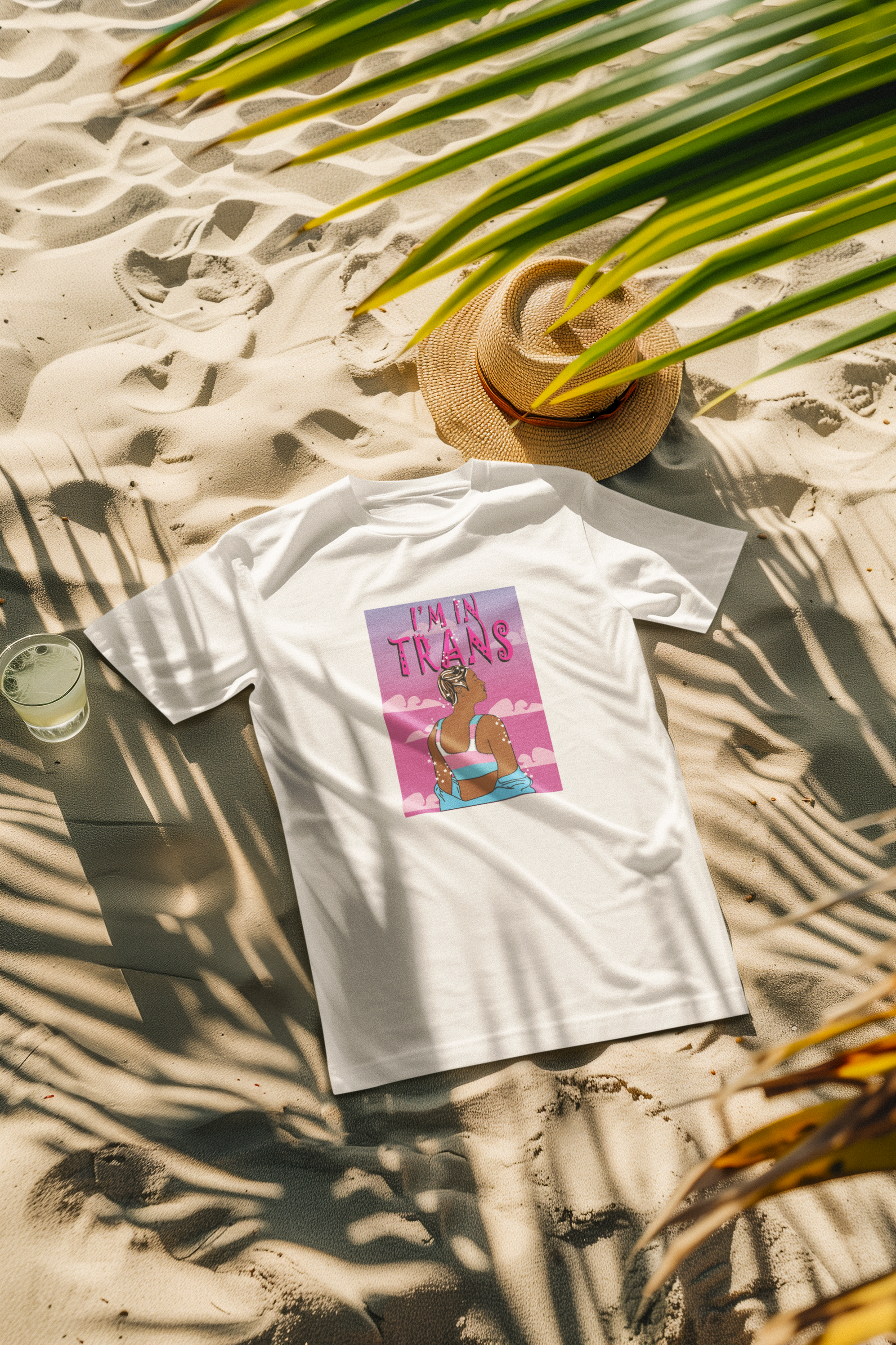 White beach-style relaxed t-shirt with black "I’M IN TRANS" print, modeled by a gender-diverse individual; breathable, inclusive pride fashion from ANTI.