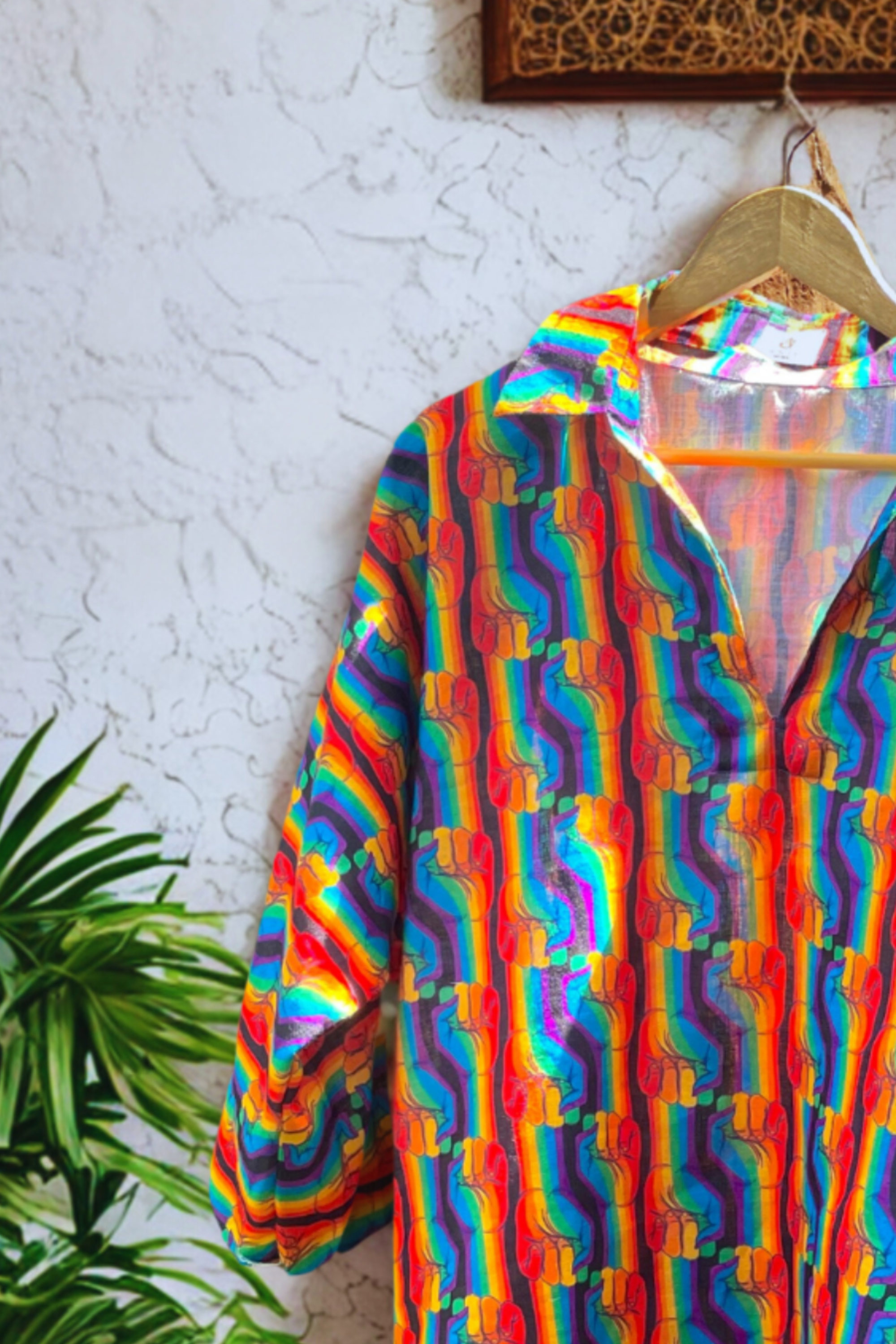 Side profile of ANTI Power Profile spectrum shirt featuring bold rainbow fists in vertical formation, open collar, and gender-neutral tailoring, celebrating LGBTQIA+ activism.