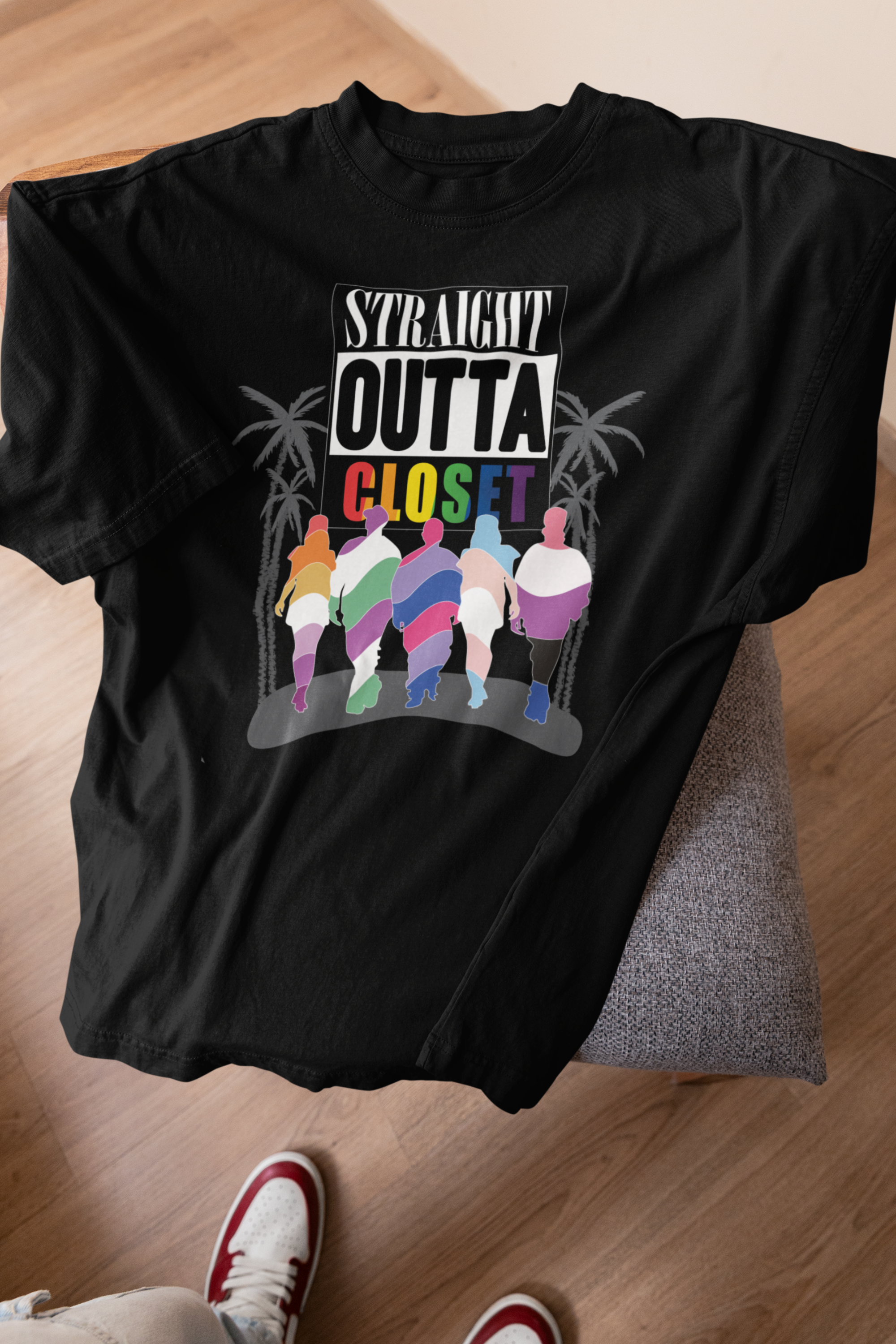 ANTI “Straight Outta Closet” black t-shirt on a stool, capturing a contrast of bold queer pride in a relaxed natural setting; inclusive, gender-fluid fashion meets freedom.