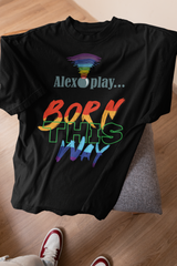 Black “Alexa, Play Born This Way” T-shirt, with bold text centered on the chest. The photo emphasizes the t-shirt’s soft texture and relaxed structure, appealing to LGBTQIA+ individuals seeking comfortable, empowering fashion. 