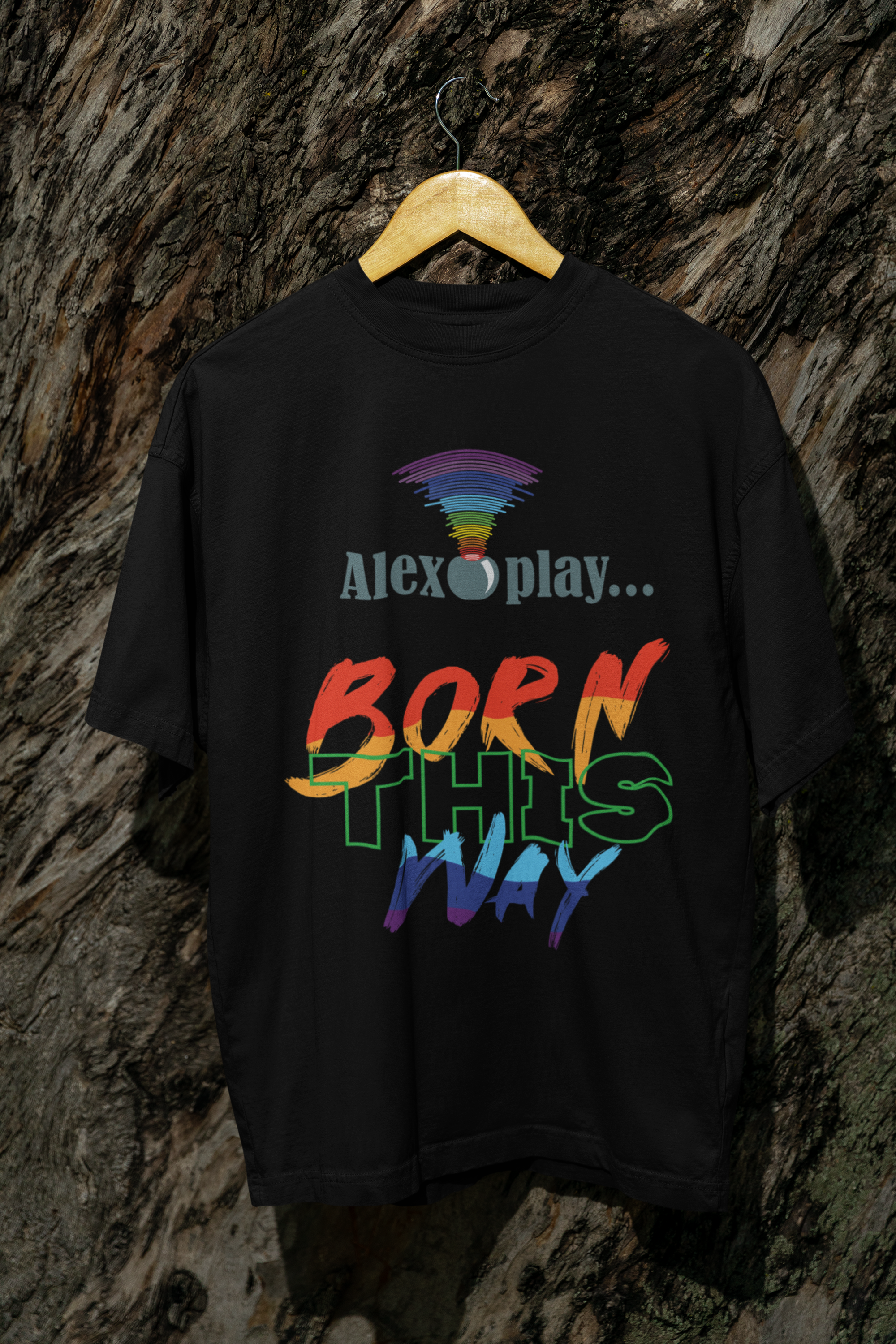 Black gender-neutral t-shirt on a stool, showcasing the black "Alexa, Play Born This Way" statement T-shirt. The shirt’s oversized cut and bold typography celebrate non-binary apparel and queer expression. Soft lighting and the model’s grounded, introspective pose communicate vulnerability and strength — core to ANTI’s inclusive fashion ethos.