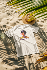 “Girl in white ‘Bi Both Ways’ graphic tee with glasses, posing at the beach; trendy LGBTQ+ beachwear with minimalist pride slogan, ideal for summer queer fashion lovers.”