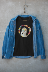 Black inclusive jacket by ANTI featuring “This Drip Is 100% Inclusive” slogan and man-with-glasses artwork; expressive urban fashion.