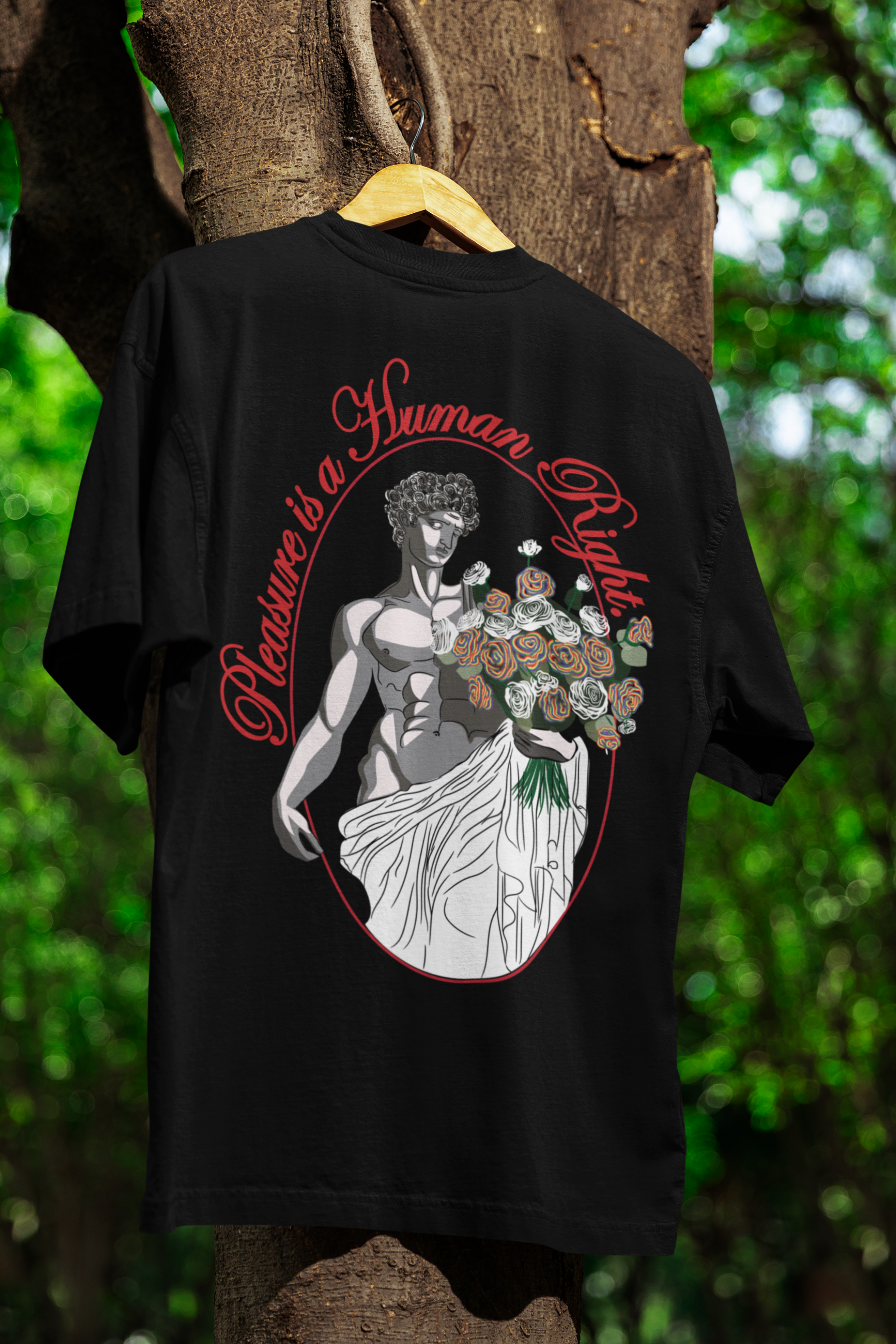 Black oversized t-shirt with bold white "Pleasure is a Human Right" print, hanging against a clean background for a minimalist, gender-inclusive look.

