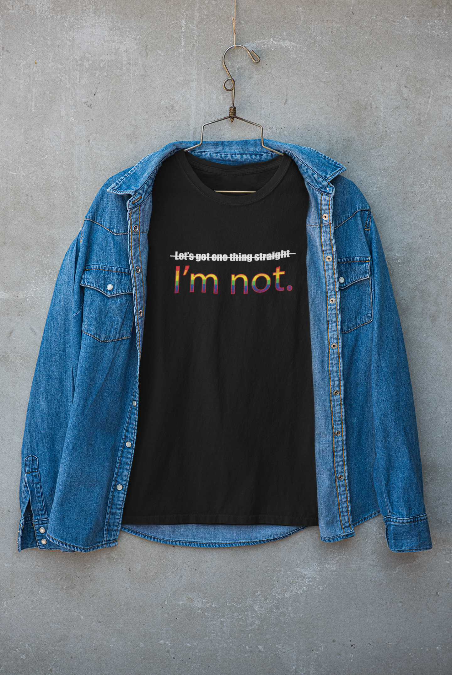 Black statement t-shirt styled beneath a jacket, with prominent white print reading "LET'S GET ONE THING STRAIGHT, I'M NOT"; photographed to highlight ANTI’s gender-inclusive aesthetic and unapologetic queer identity.