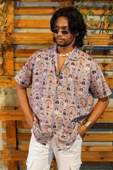 Person wearing a colorful patterned shirt with a wooden wall background