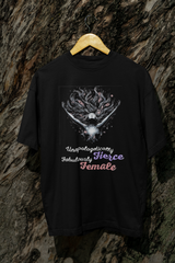 Empowerment grows wild here. Shot hanging from a tree in natural light, this oversized black tee channels grounded strength and fearless femininity. With the bold white “Unapologetically Fierce, Fabulously Female” print, this shirt blends rebellion with serenity—perfect for anyone rooted in authenticity.