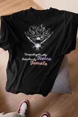 Black oversized tee with white empowering slogan displayed on stool in minimal indoor setup.