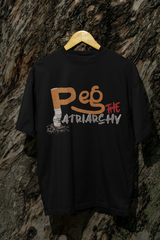 Black oversized t-shirt with white “Peg the Patriarchy” slogan, displayed hanging on a tree. Designed with a boxy, gender-neutral silhouette, this statement shirt from ANTI embodies queer activism and bold streetwear style.
