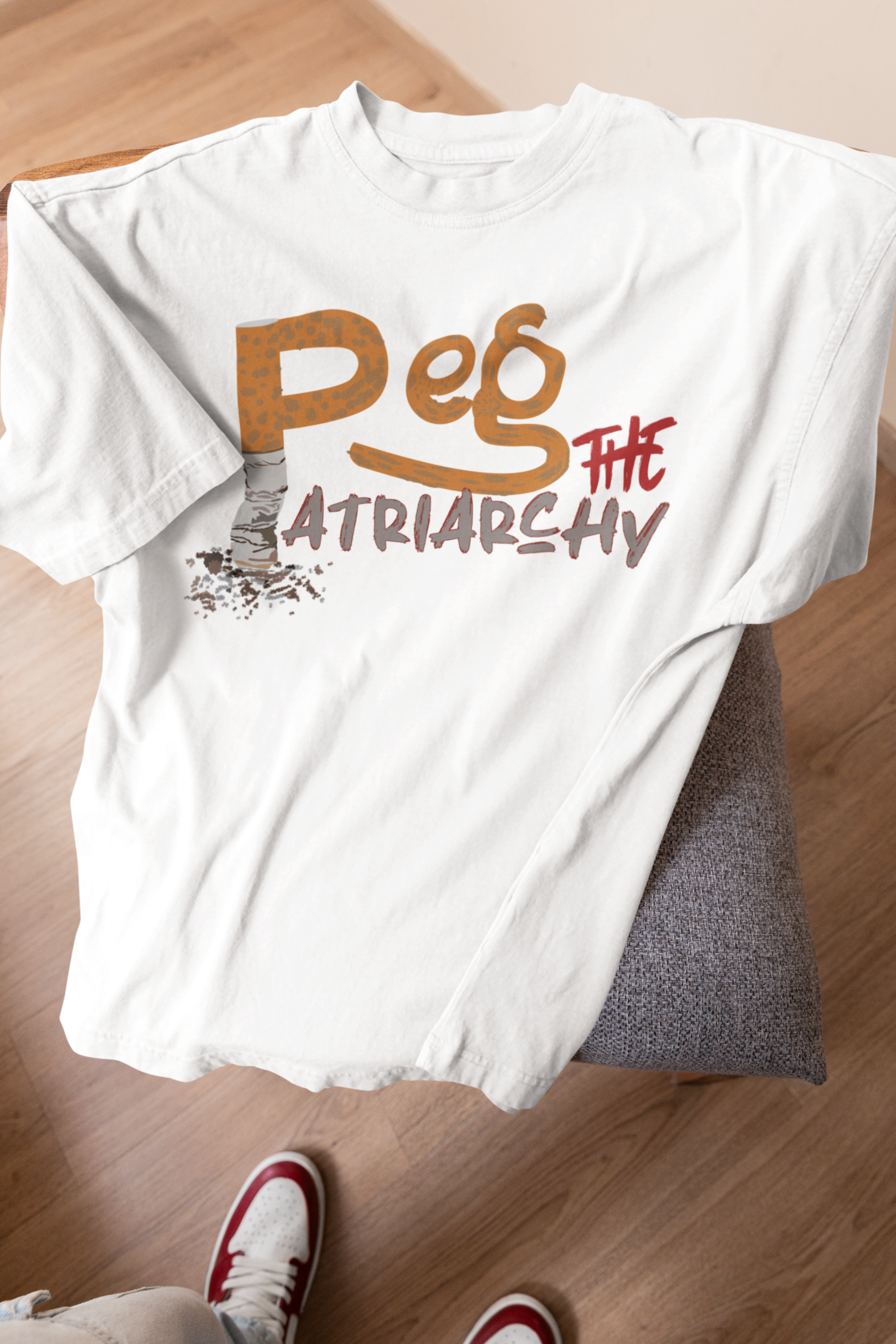 Oversized white t-shirt with strong “Peg the Patriarchy” lettering, styled on a minimalist t-shirt. This inclusive fashion piece features a roomy, unisex cut and represents queer defiance through elevated streetwear.
