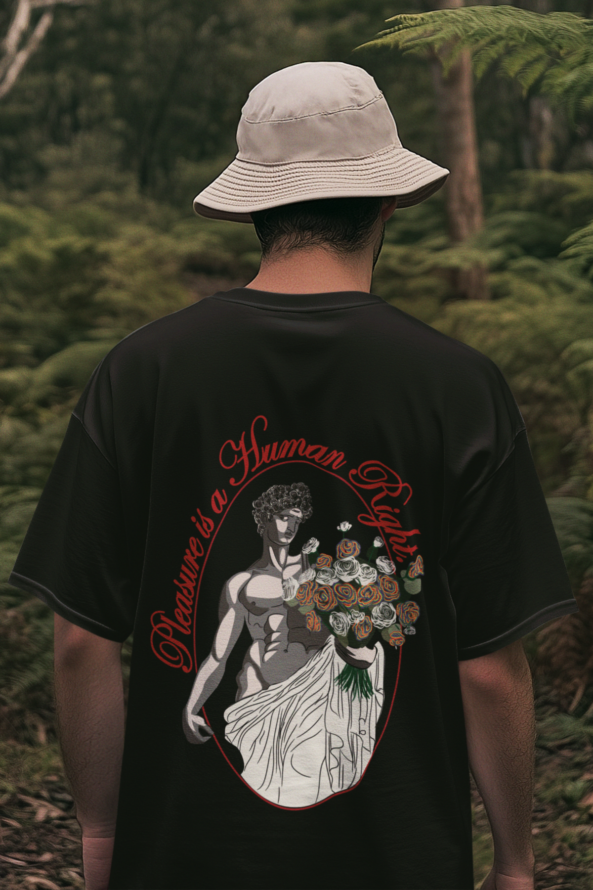 Black oversized t-shirt with bold white "Pleasure is a Human Right" print, hanging against a clean background for a minimalist, gender-inclusive look.

