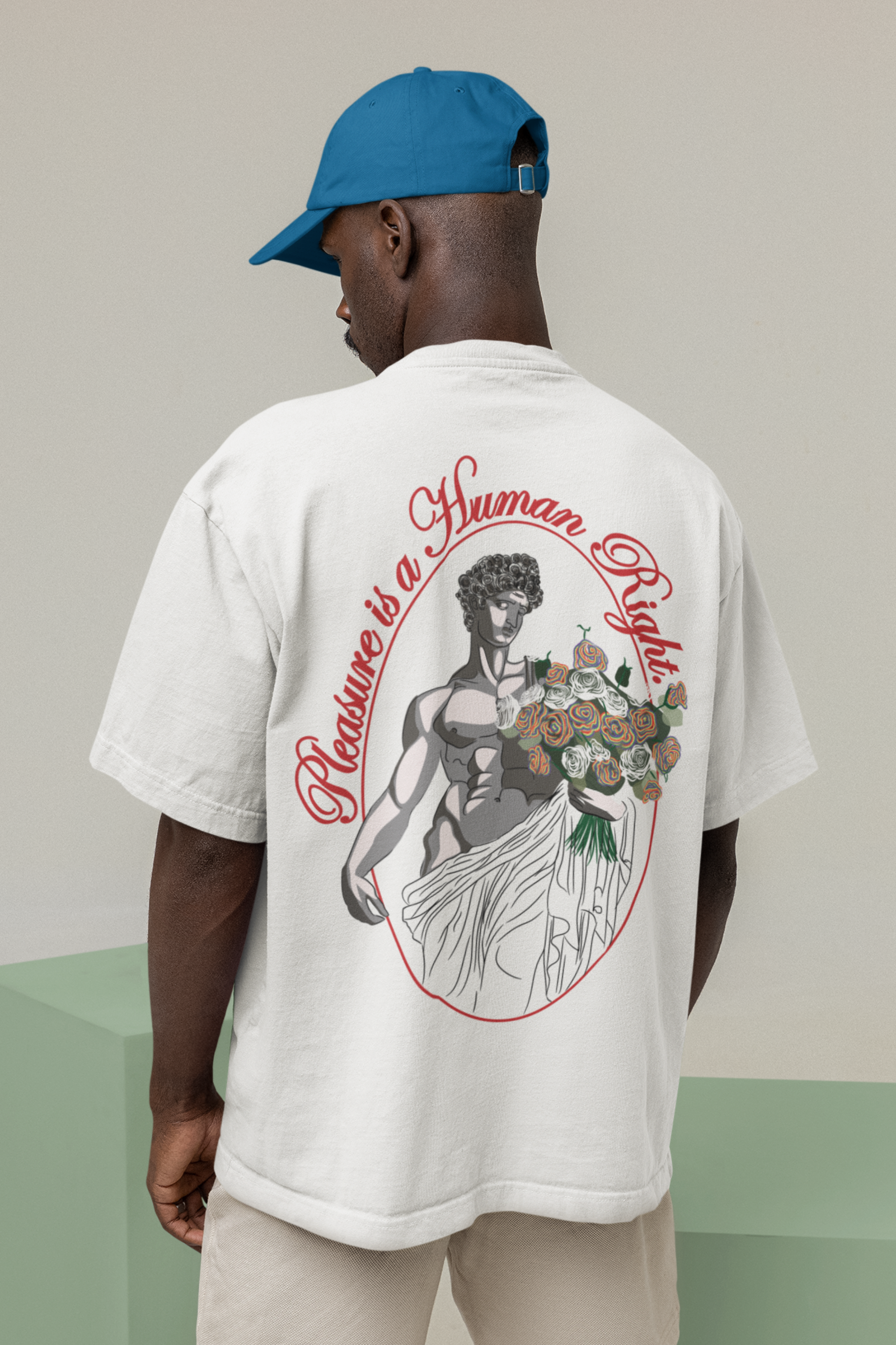Model in white oversized t-shirt featuring “Pleasure is a Human Right” in black—queer-forward fashion, body-positive, and street-ready.

