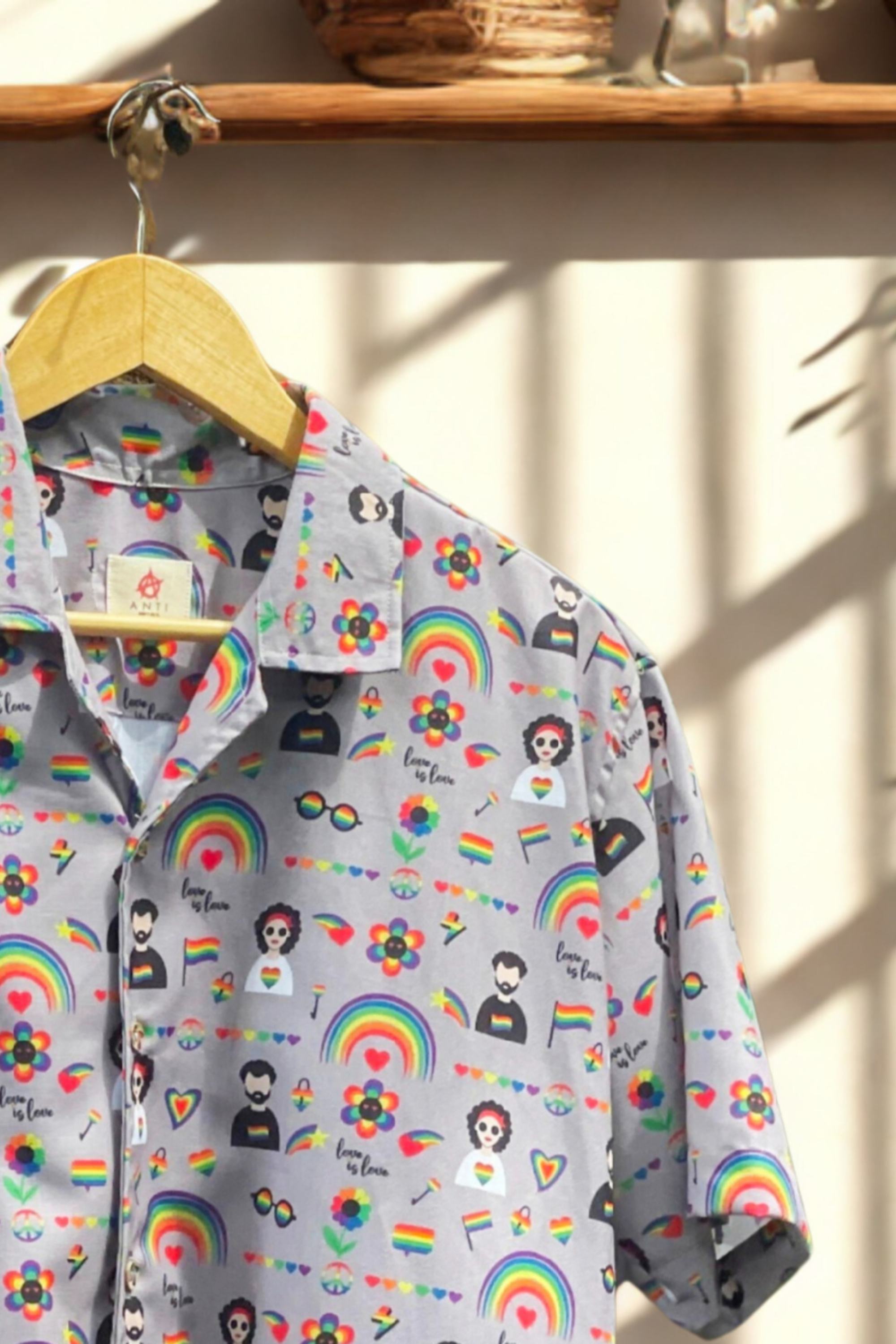 Close-up of ANTI’s LGBTQIA+ unisex pride shirt showcasing detailed rainbow motifs, queer-themed illustrations, and bold symbols of love and inclusivity on soft lavender fabric.