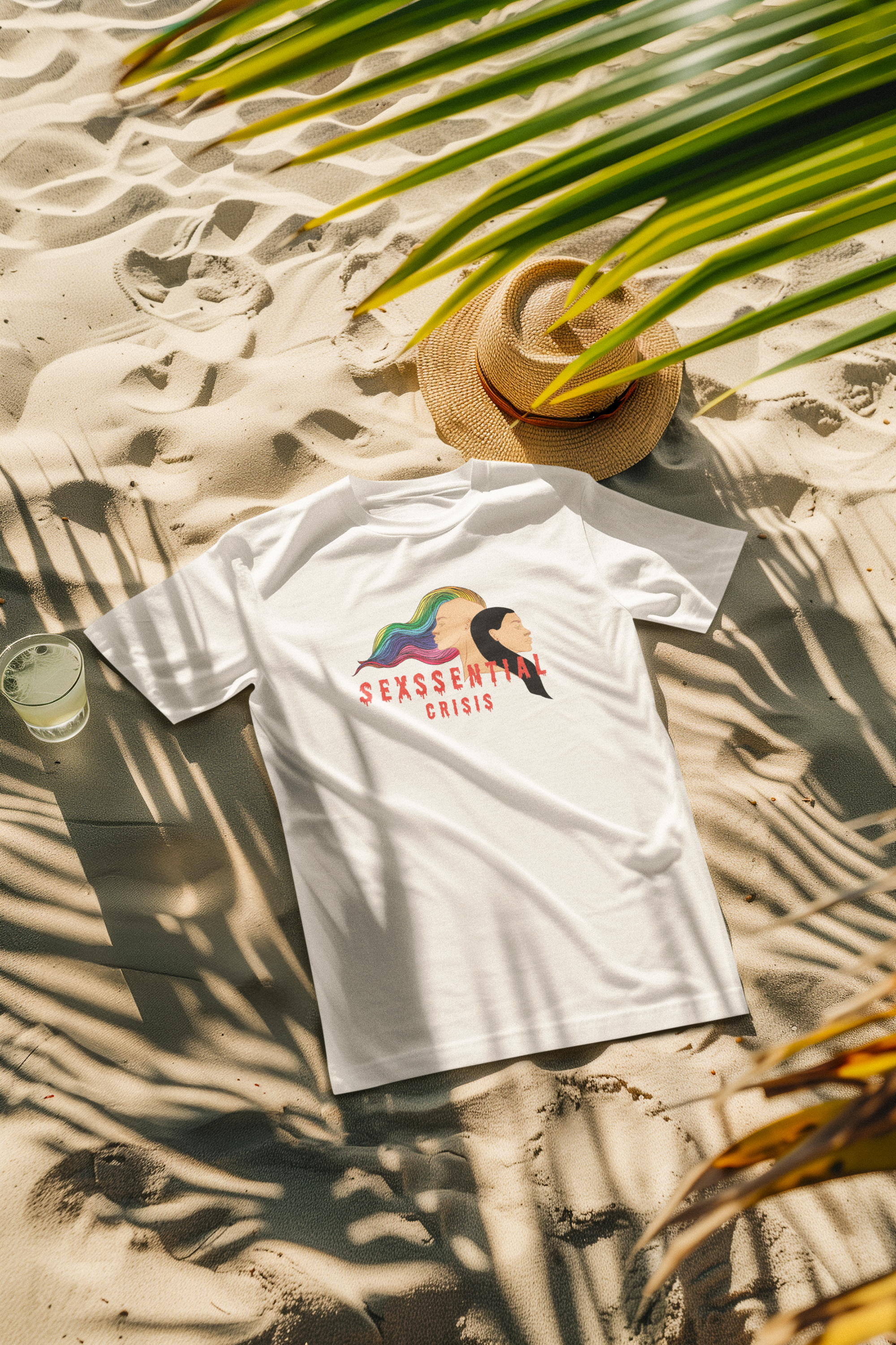 Model wearing a bold white unisex t-shirt from ANTI’s “Sexssential Crisis” collection, featuring dual-head abstract graphic art; designed for all gender identities, perfect for fluid beach fashion.