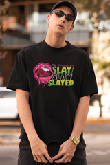 Bold, gender-fluid cropped jacket in black and white featuring graffiti-style "SLAY SLAY SLAYED" text across the back, worn by a model in a confident stance; designed by ANTI for streetwear lovers and LGBTQIA+ expressive fashion.