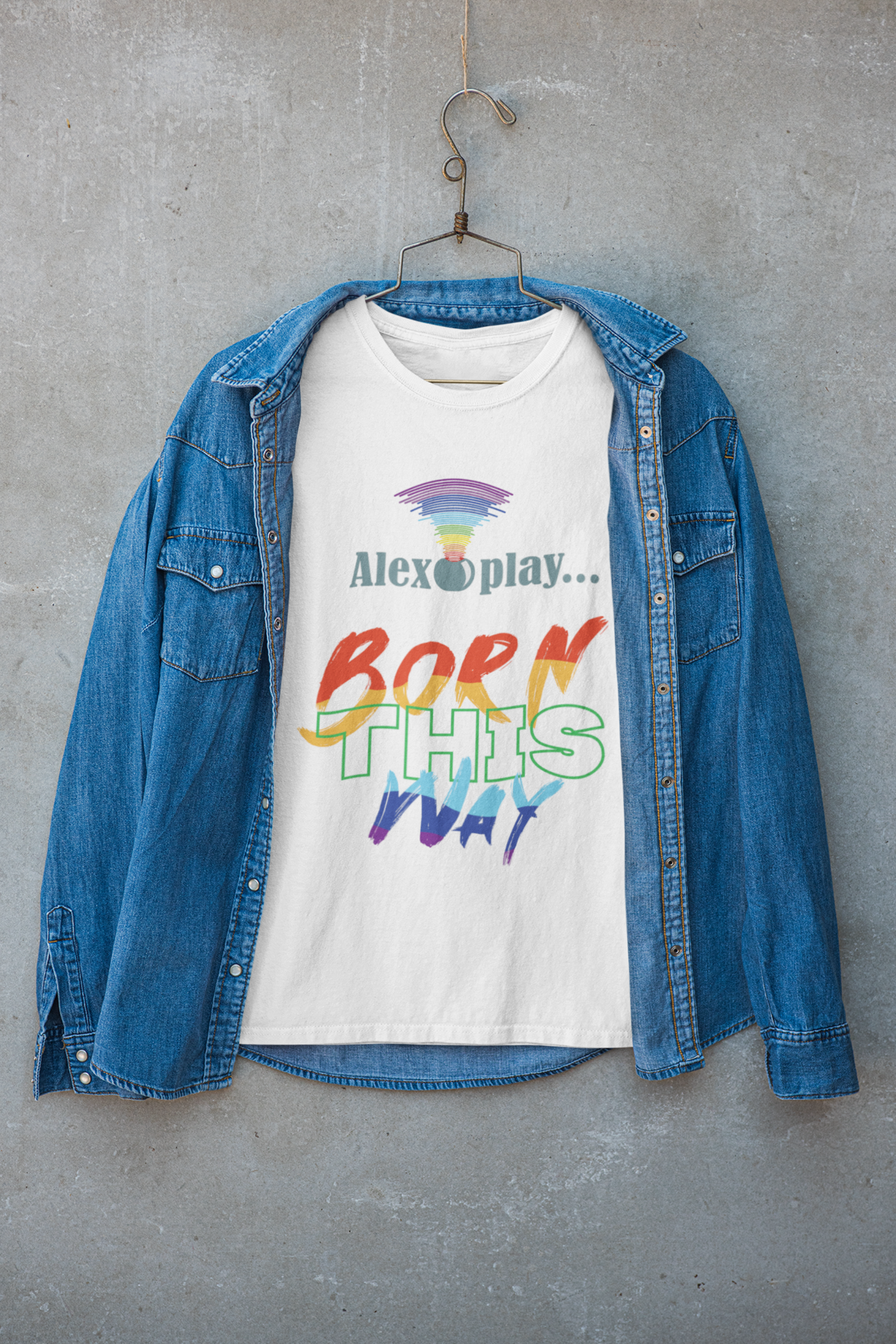 White UNISEX “Born This Way” tee styled under a jacket, merging clean minimalism with bold LGBTQIA+ self-expression.


