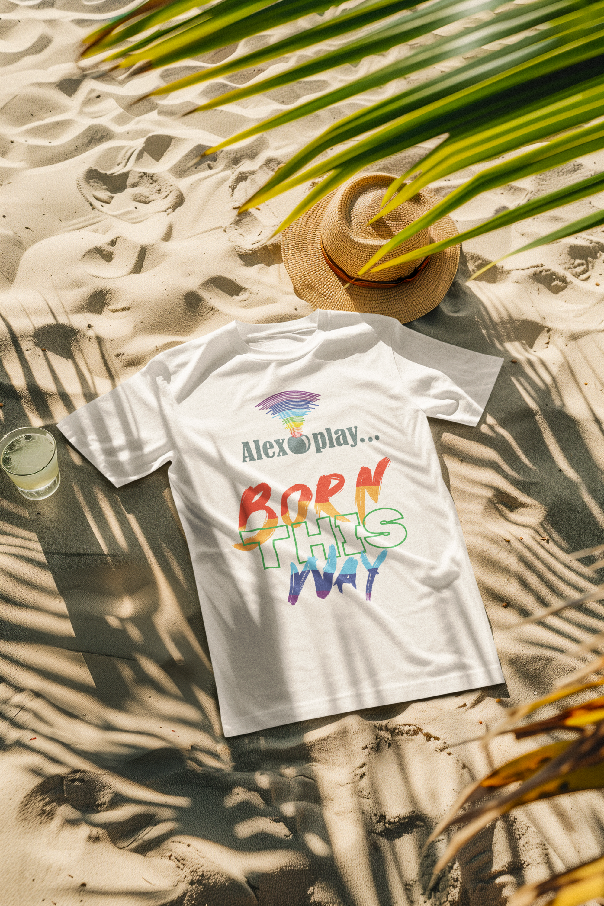 Wear white “Born This Way” UNISEX tee on the beach with black shorts and boots, embracing sunlit queer rebellion.