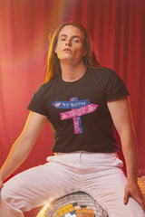 "Model wearing ANTI's unisex black T-shirt with 'By Both Ways' wooden arrow design, sitting on a disco ball with white pants – bold, expressive clothing celebrating bisexuality and queer identity."
